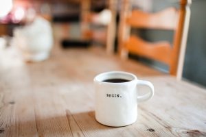 coffee cup on table that reads "begin"